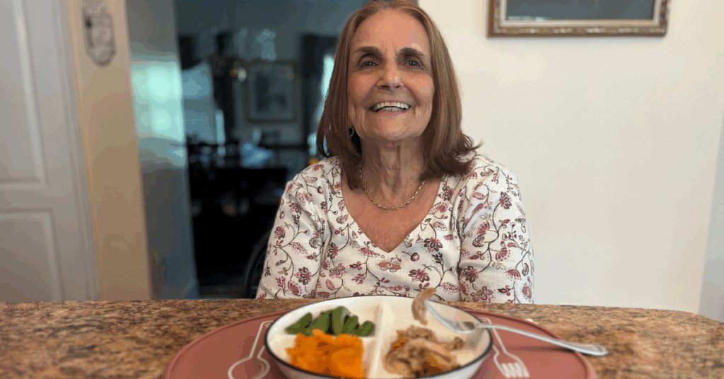 Our mom smiling at the table with a fresh, brain-healthy meal